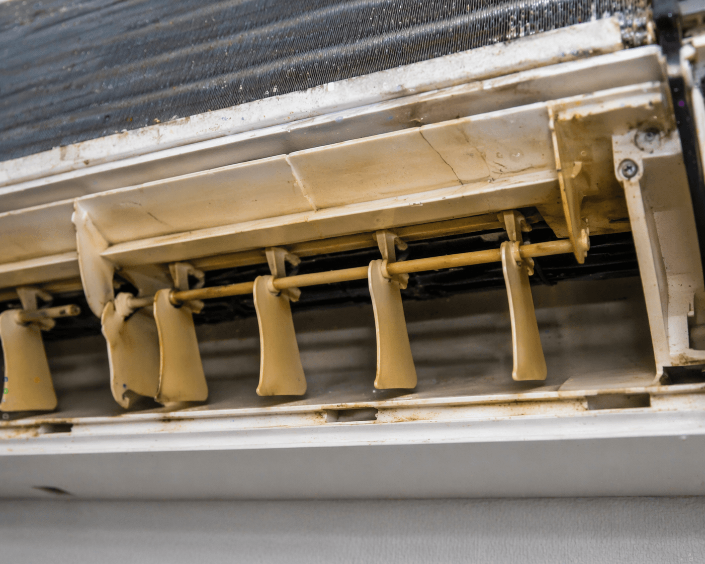 пожълтели и напукани пластмаси на вътрешно тяло на климатик от прегряване